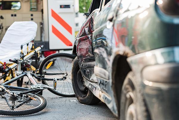 uszkodzony rower leżący na ulicy po zderzeniu z samochodem
